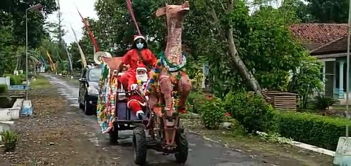 RAYAKAN NATAL 2020, SINTERKLAS DI JEMBER KENDARAI TRAKTOR PEMBAJAK SAWAH UNTUK BAGIKAN HADIAH