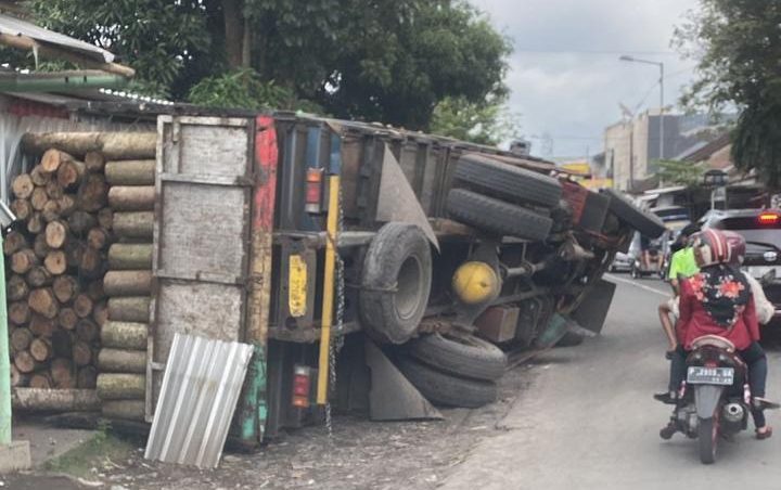 TRUK BERMUATAN KAYU SENGON TERGULING, TIMPA PICK UP DI KALISAT