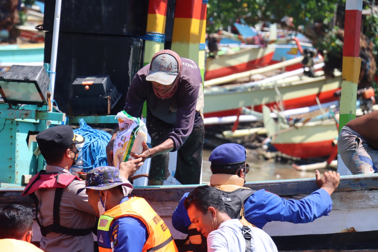 SUSURI PANTAI PUGER DENGAN KAPAL, POLRES JEMBER BAGI-BAGI RATUSAN PAKET SEMBAKO PADA NELAYAN